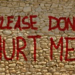 Mauer mit großer roter Schrift: Please don't hurt me!