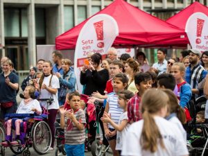 Menschen mit und ohne Rollstuhl beim Fackellauf in Berlin