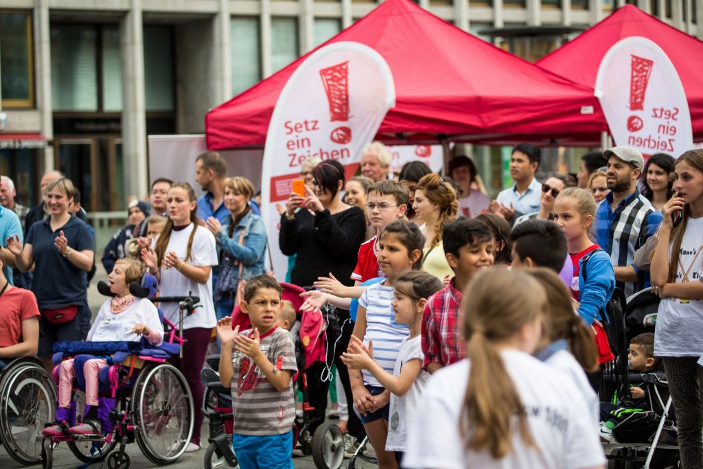 Menschen mit und ohne Rollstuhl beim Fackellauf in Berlin